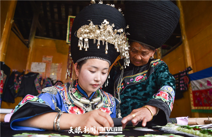 在貴州省銅仁市松桃苗族自治縣太平營(yíng)街道老寨村，一老人在指導(dǎo)繡娘繡苗繡。.jpg