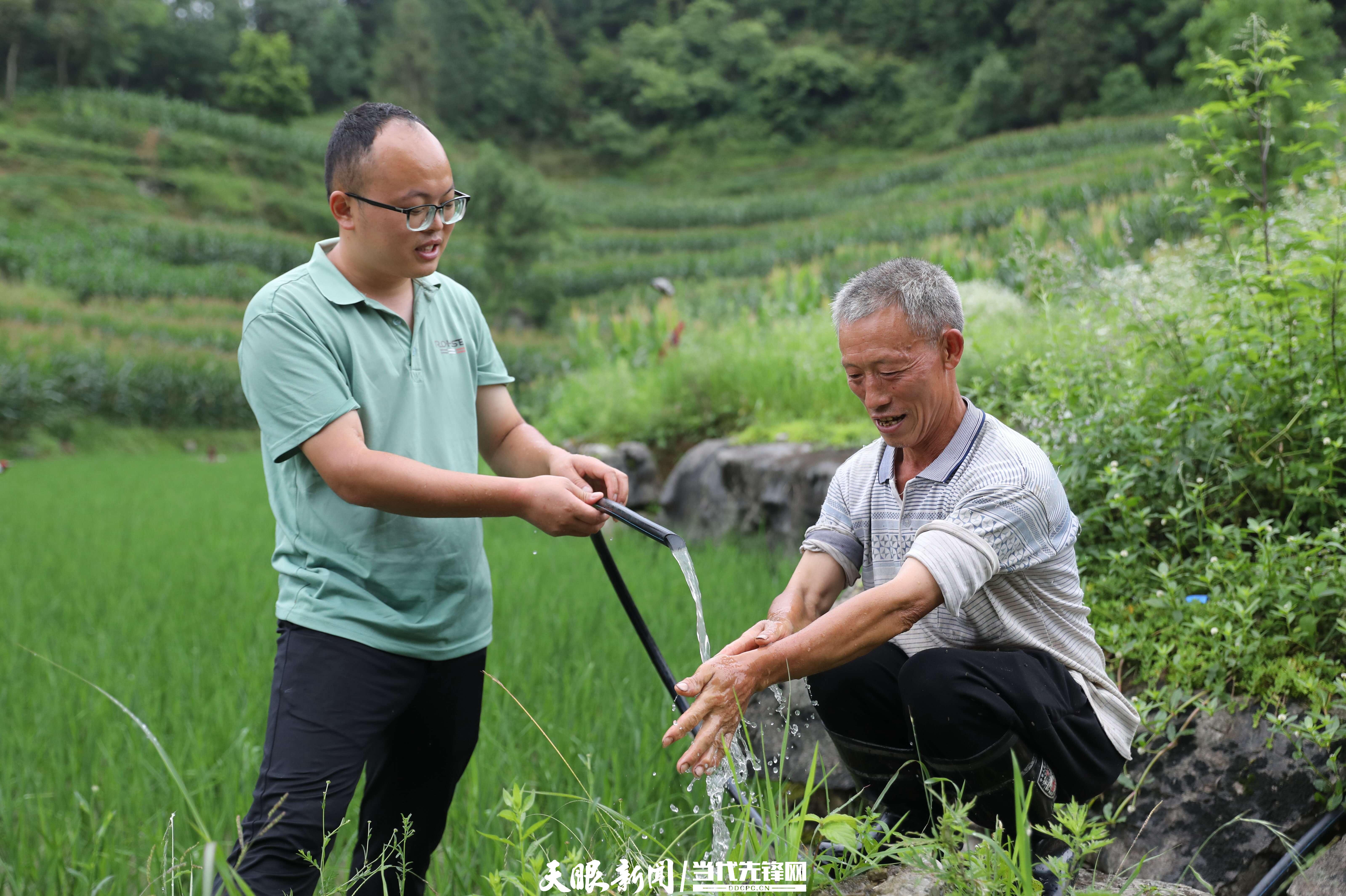 水通了，干部舉起水管給村民洗手（吳昌華右）（潘婭攝）.JPG
