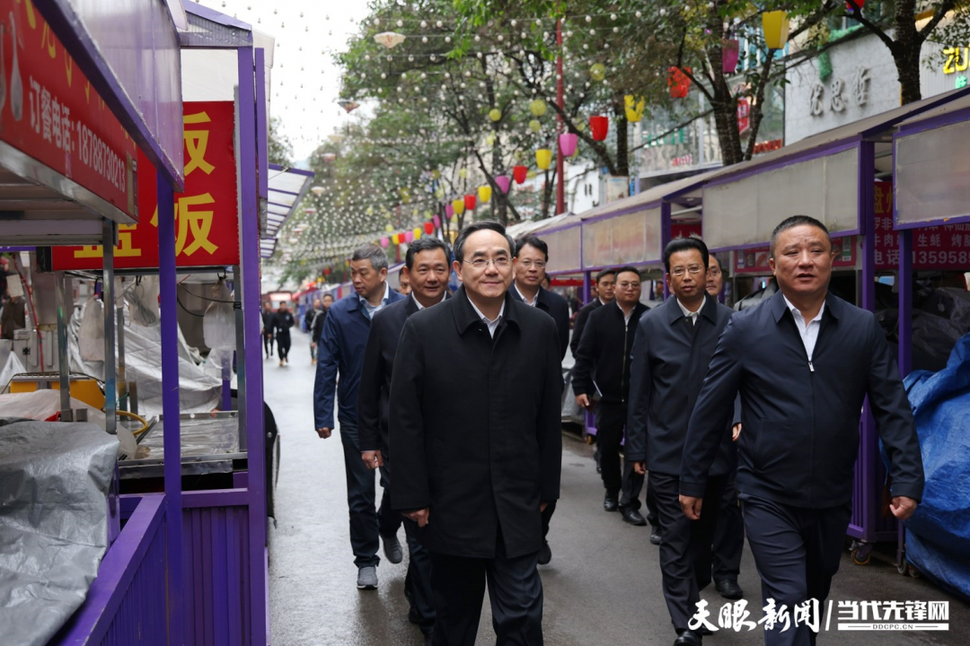 圖為徐麟在盤州市亦資街道三峽北路小吃一條街，察看店面攤點(diǎn)管理情況。.jpg